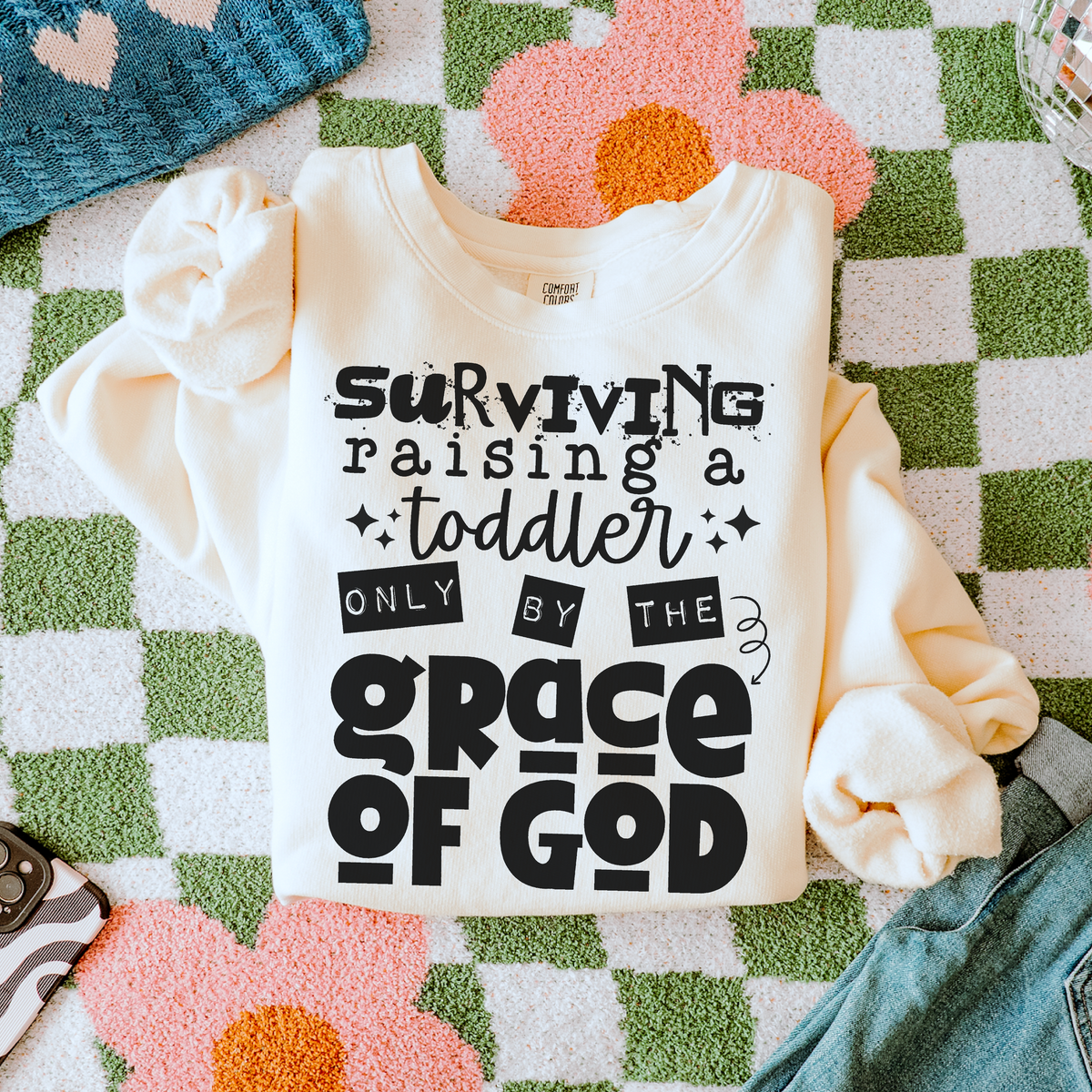 Surviving a toddler by the Grace of God (BLACK) (two peas) DTF Transfer