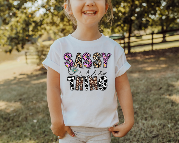Sassy little thing (block letters with leopard, purple & black checker print, leopard & cow print, smiley faces, colorful) 1818 DTF TRANSFER