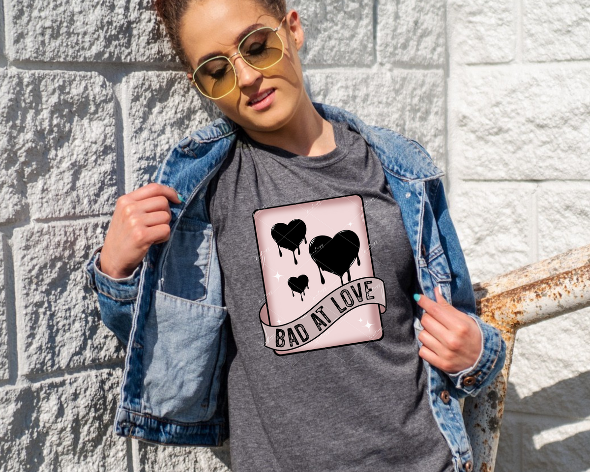 Bad At Love (dusty pink, playing card, black hearts, wrapped ribbon, block distressed lettering) 1222 DTF TRANSFER