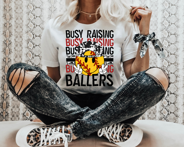 Busy Raising Ballers (yellow soft ball, black, and red block distressed lettering) DTF TRANSFER